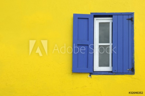 Bild på Colorful yellow house with blue shutters in Governors Harbour